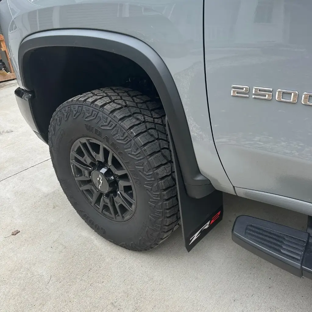 PKG Chevy 2500 ZR2 Front drill‑less mud flaps with semi-gloss black powder coated ZR2 weights & color behind, 2024 – Current 
