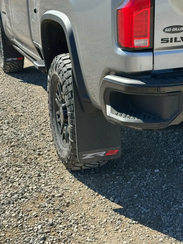 PKG Chevy 2500 ZR2 Rear drill‑less mud flaps with semi-gloss black powder coated ZR2 weights & color behind, 2024 – Current 