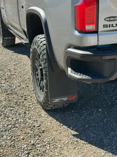 [009672] PKG Chevy 2500 ZR2 Rear drill‑less mud flaps with semi-gloss black powder coated ZR2 weights & color behind, 2024 – Current 